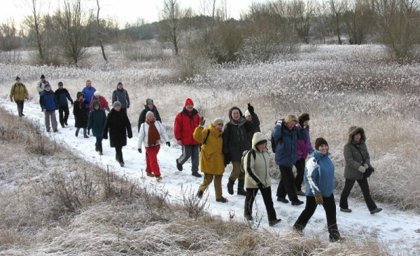 Grupa turystów wędrująca w zimowym krajobrazie
