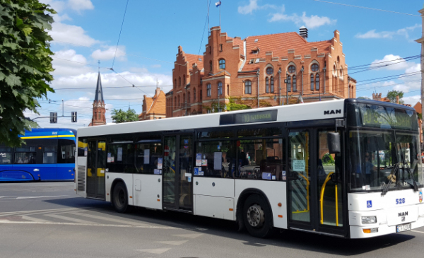 Na zdjęciu: autobus i tramwaj na tle Urzędu Miasta Torunia