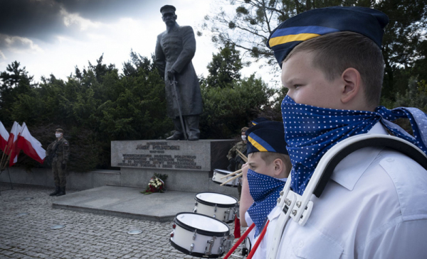 Chłopiec dobosz na tle pomnika Piłsudskiego w Toruniu