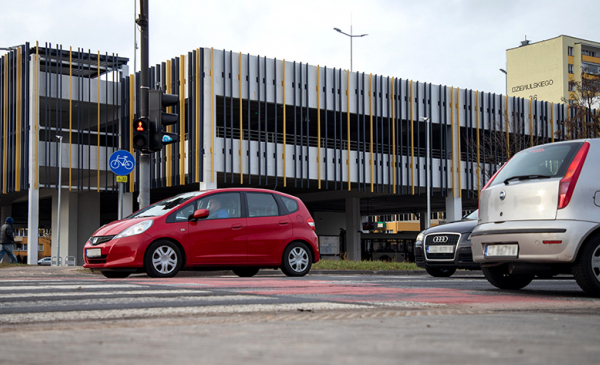 Budynek parkingu na Rubinkowie_z przodu czerwone auto