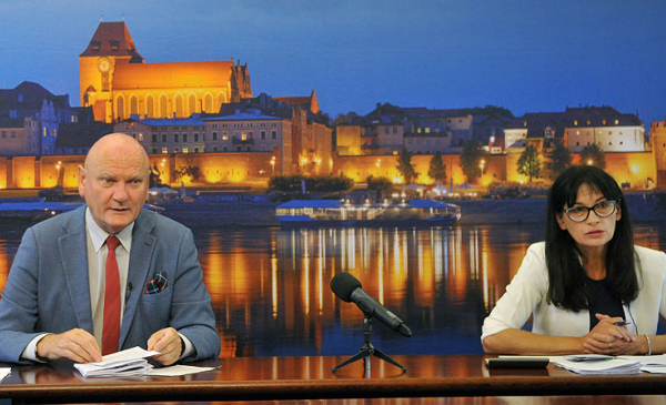 Na zdjęciu widać prezydenta miasta Torunia Michała Zaleskiego i skarbnika miasta Magdalenę Flisykowską-Kacprowicz siedzących przy stole konferencyjnym w czasie konferencji prasowej