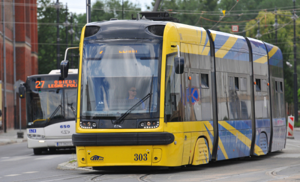 Na zdjeciu: żółto-niebieski tramwaj i biały autobus