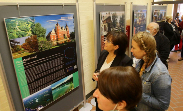 Na zdjęciu: kobiety oglądają zdjęcia na wystawie obiektów na liście UNESCO