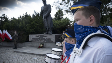 Chłopiec dobosz na tle pomnika Piłsudskiego w Toruniu