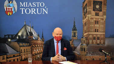 Na zdjęciu prezydent Michał Zaleski z czerwoną maseczką podczas konferencji