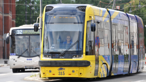 Na zdjęciu: żółty tramwaj i biały autobus miejski