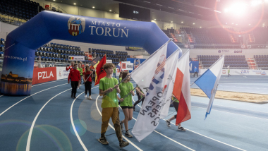 Na zdjęciu: zespoły zawodników z flagami wchodzą do hali na bieżnię