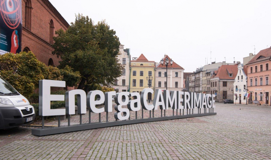 Napis EnergaCamerimage ustawiony na Rynku Nowomiejskim, w tle siedziba festiwalu - Fundacja Tumult