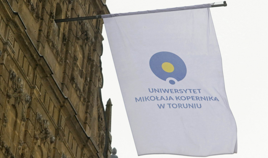 Flaga UMK na budynku Collegium Maximum 