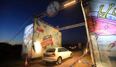 Na zdjęciu widać podświetloną bramę wjazdową na teren festiwalu Auto Skyway i samochód, który w nią wjeżdża