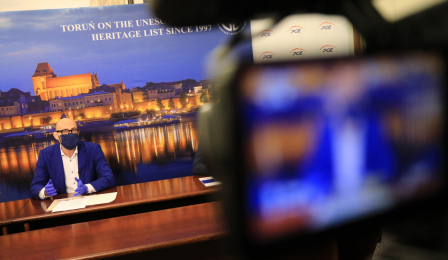 Zastępca prezydenta Zbigniew Rasielewski podczas konferencji prasowej, na pierwszym planie widoczna kamera
