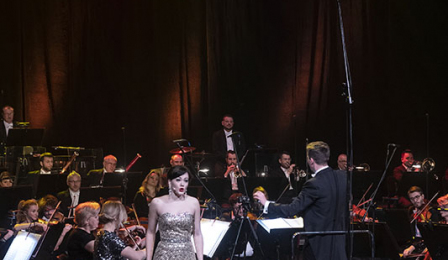 Sopranistka Aleksandra Borkiewicz ubrana w długą srebrną suknię śpiewa podczas koncertu