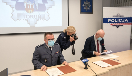 Na zdjęciu rzeczniczka KMP w Toruniu fotografuje porozumienie